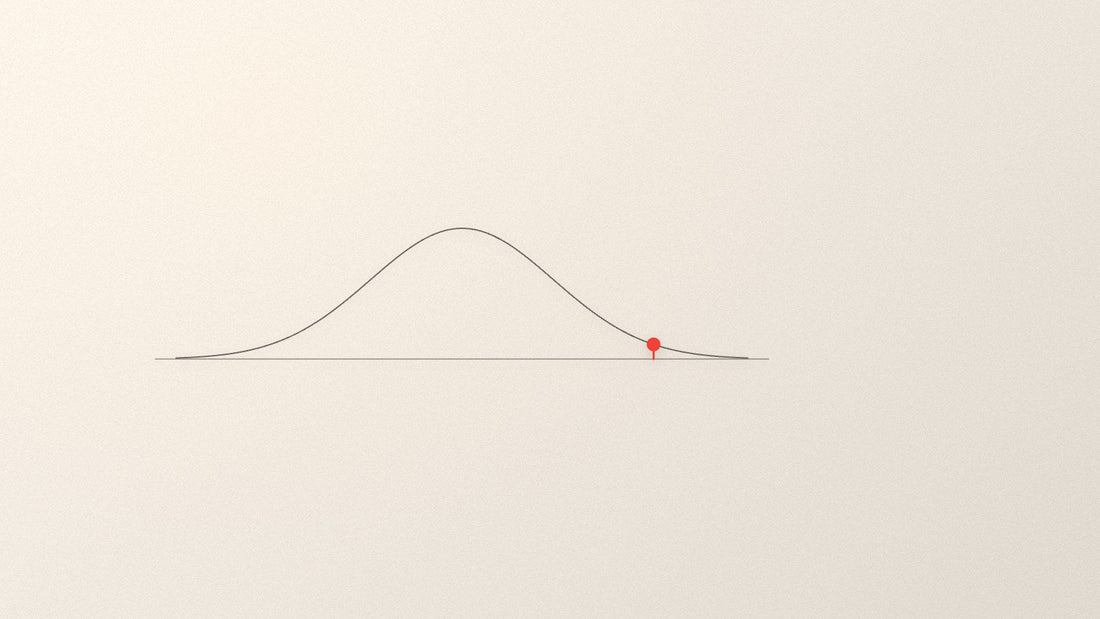 A fine distribution curve with one point marked in red well outside its centre.
